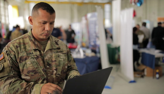 military service member typing on a laptop at a hiring event