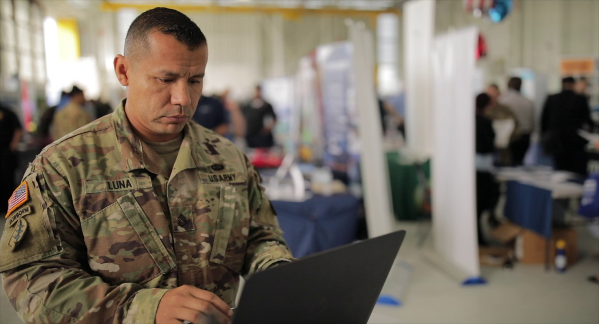 military service member typing on a laptop at a hiring event