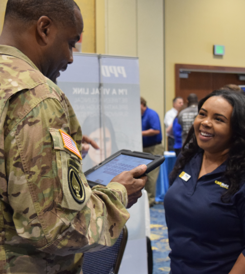 a man in uniform interacts with an employer at a hiring fair