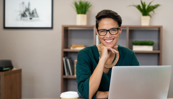 smiling woman sitting at a computer