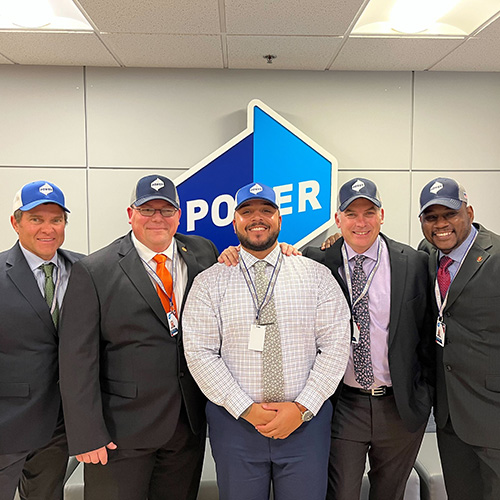 NCR Fellows Power HRG Day 1 - men smiling, posing with Power hats