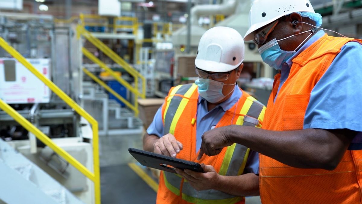 Two workers talk inside a Nestlé USA factory