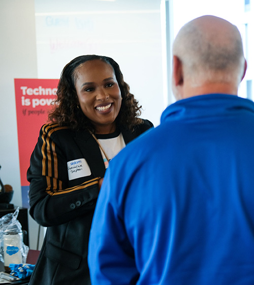 Woman having a conversation with a man whose back is to the camera at tech event.