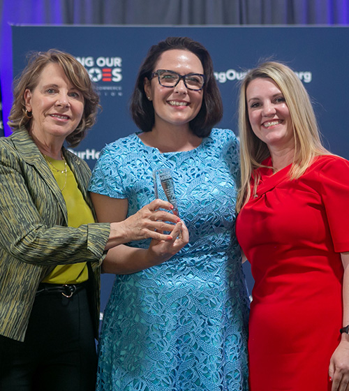 Three women accept an Entrepreneur Impact Award on behalf of Instant Teams.