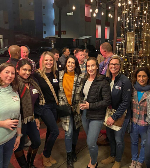 Networking women smile for the camera outside a restaurant in San Diego