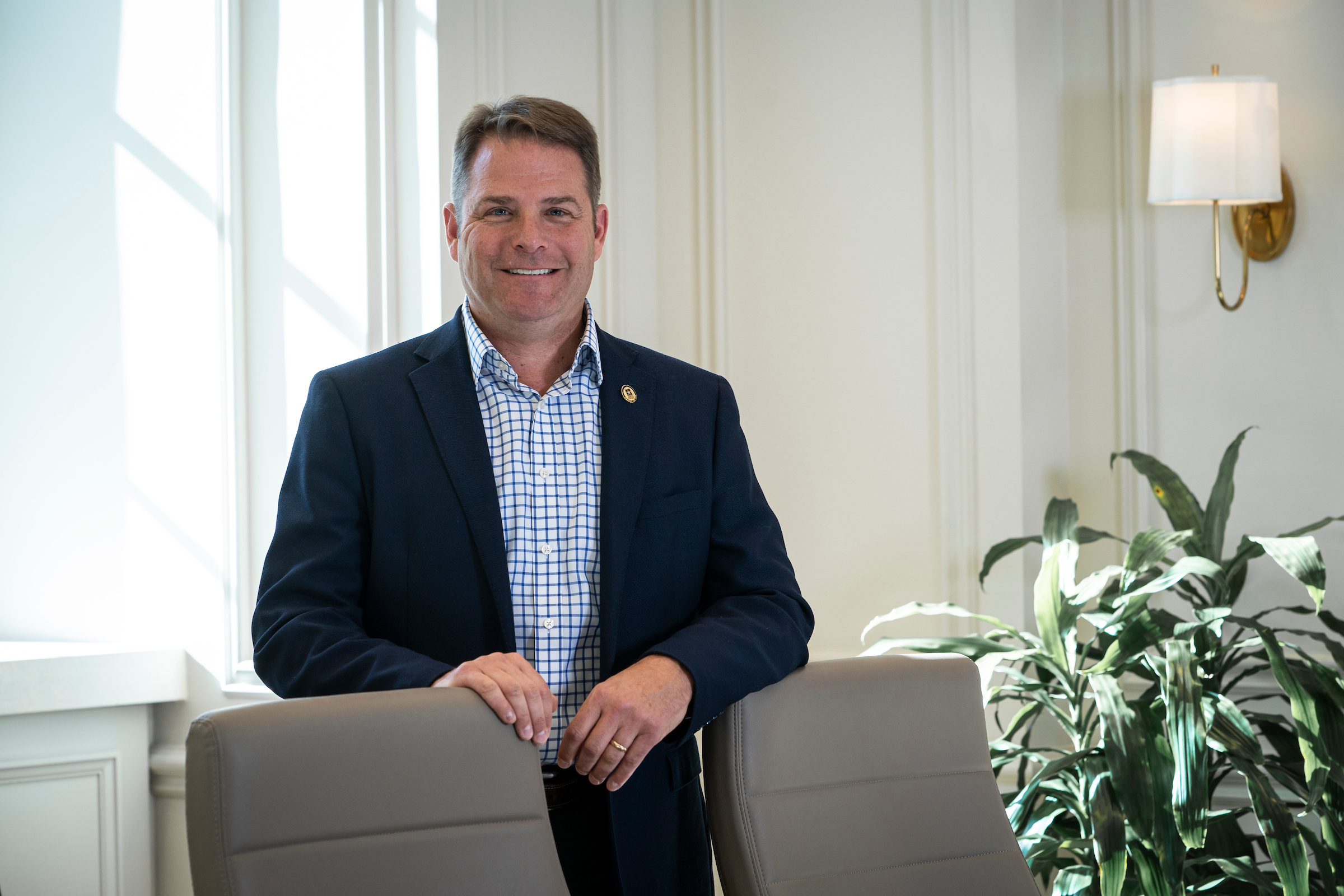 Adam Rocke poses for a photo in a conference room with good natural lighting