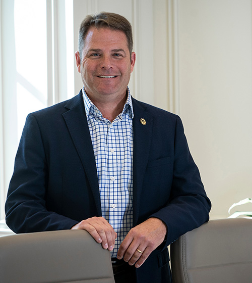 Adam Rocke poses for a photo in a conference room with good natural lighting