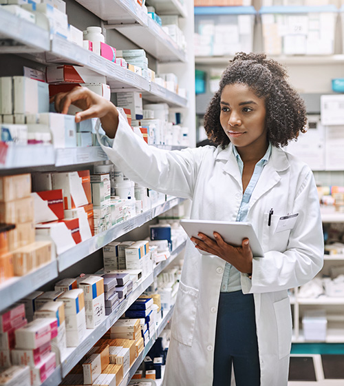 Pharmacy technician female wearing a white lab coat, picking out prescriptions