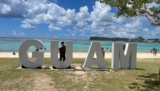 Navy spouse with Guam letters at beach