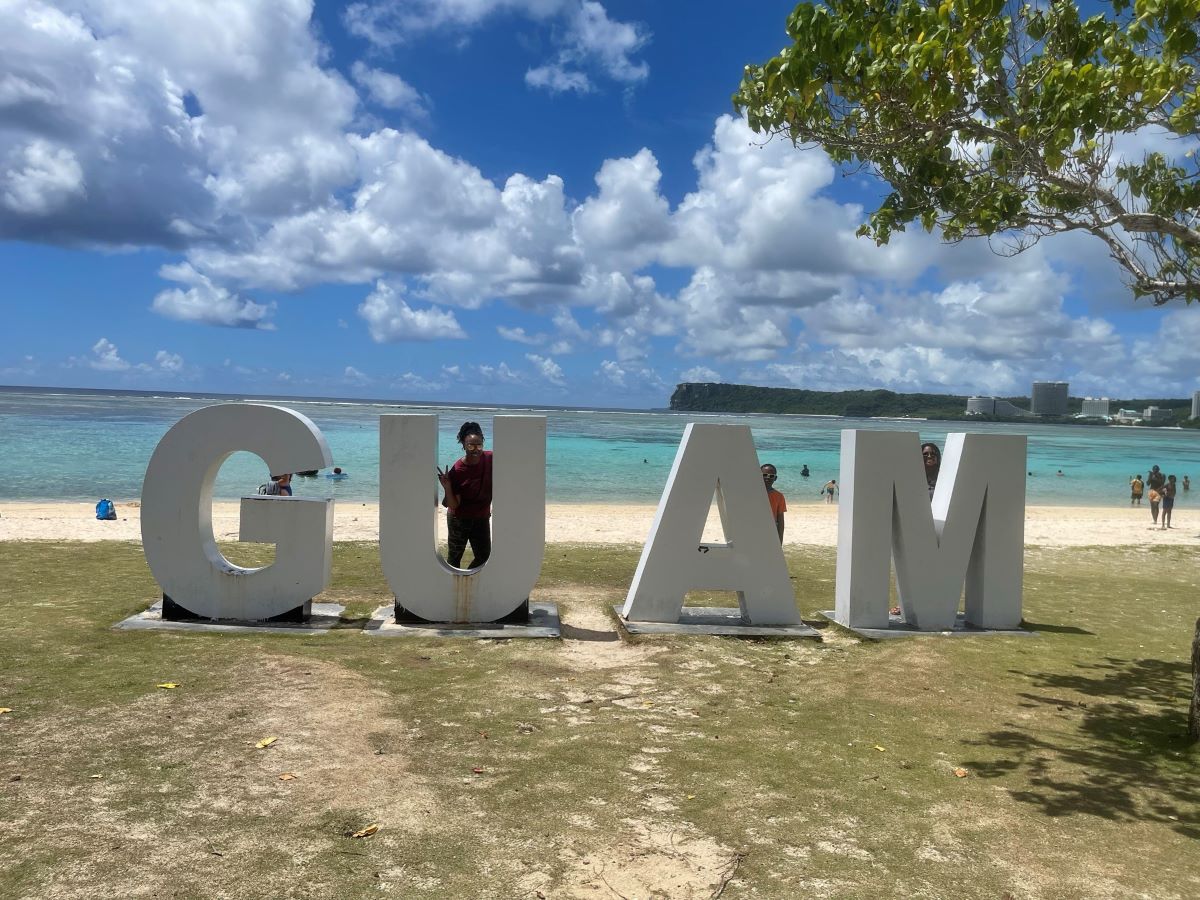 Navy spouse with Guam letters at beach