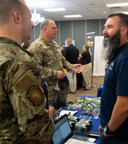 service members speak with an employer at a hiring fair