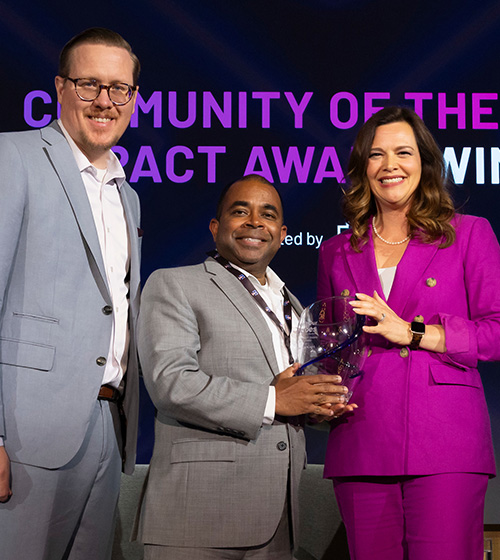 Community of the Year Impact Award Winner Sultan Camp (center) accepting on behalf of Hampton Roads during Hiring Our Heroes Military Spouse Employment Summit 2025.