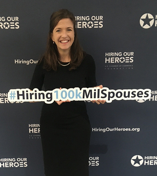 Former HOH fellow Allison Gunta smiles while holding a sign from the #Hiring100kMilSpouses campaign.