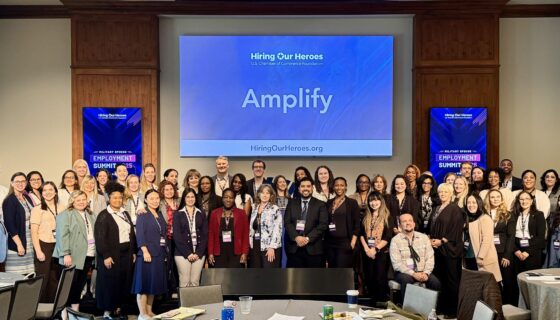 Some of the Amplify 2025 participants pose in front of Amplify screen.