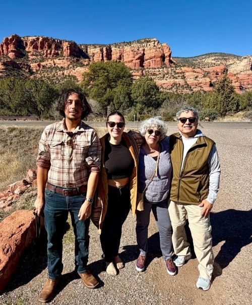 Ashley and her family pose in front of a rock formation.