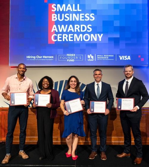 Small Business Awards Ceremony photo of the winners smiling and holding certificates at the event