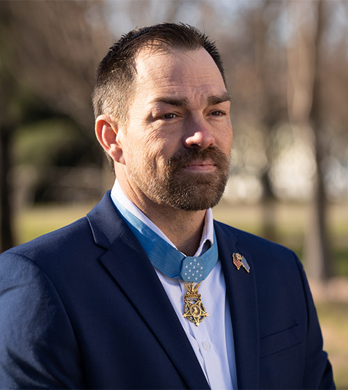Hiring Our Heroes Ambassador Clint Romesha headshot taken outdoors.