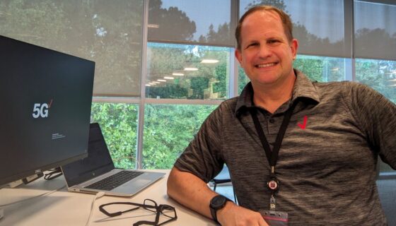 Marc Gaguzis sits at his desk with his Verizon computer.