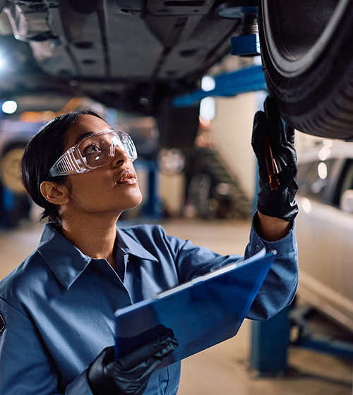 Skilled Trades Academy Automotive Pathway - woman inspecting a vehicle's wheel
