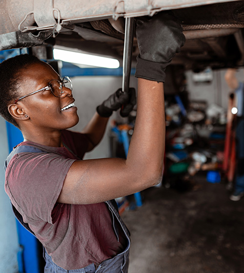 Skilled Trades Academy Automotive Pathway - woman working on the underside of a vehicle