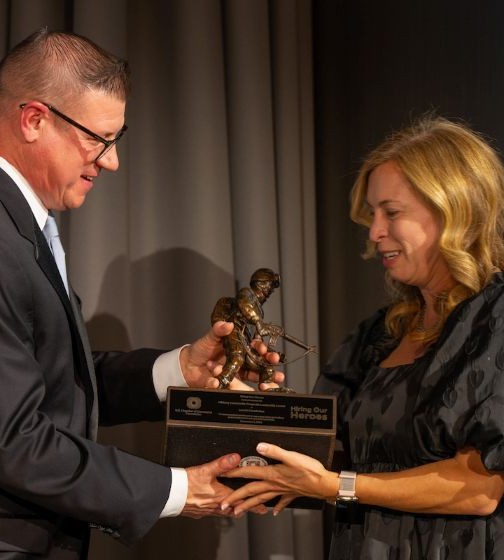 Recipient receives her award on stage at the Hiring Our Heroes Awards Gala.