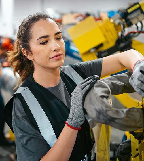 A female works with her hands in a manufacturing plant