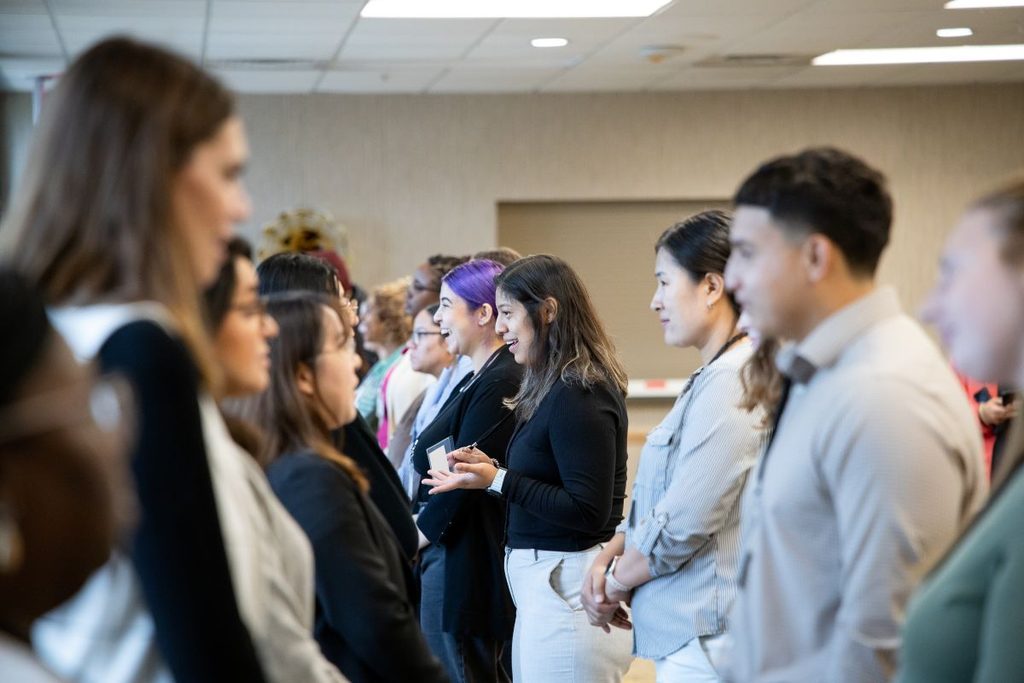 Two lines of people face each other to work on their elevator pitch.