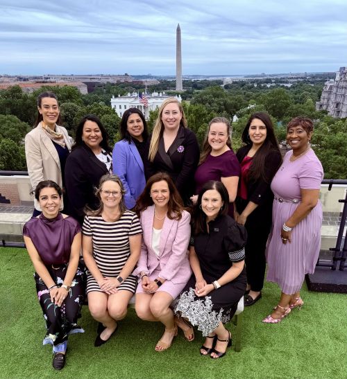 Military spouse team poses on the U.S. Chamber rooftop overlooking Washington D.C.