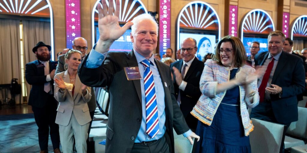 Dr. Ken Hartman waves to the crowd at the Our Community Salutes event attendees at the Chamber of Commerce in June 2026. 